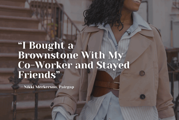 Nikki Merkerson smiling in front of a Brooklyn brownstone, dressed in a belted coat and layered shirt