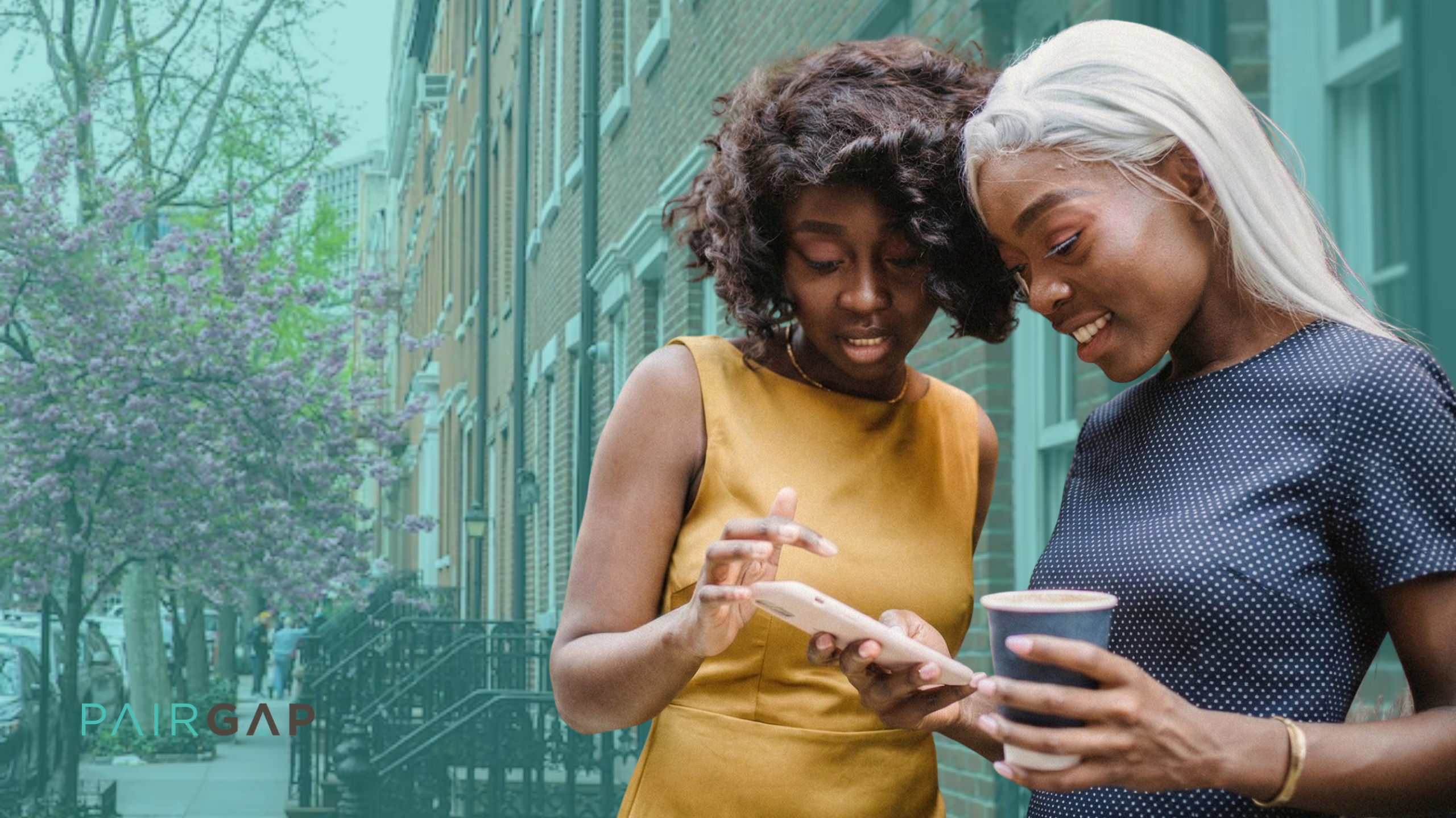 Two women stand on a tree-lined city sidewalk in spring, smiling as they look at a phone together, with the Pairgap logo visible in the lower left corner.