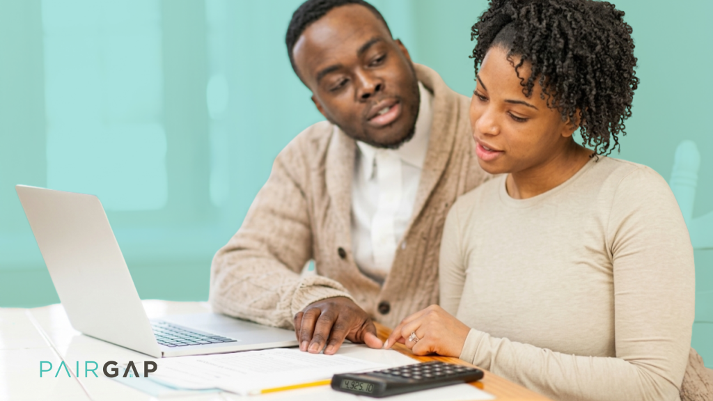 Couple reviewing mortgage and budgeting documents while planning to co-buy a home together in 2026