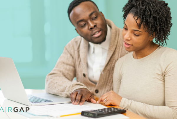 Couple reviewing mortgage and budgeting documents while planning to co-buy a home together in 2026