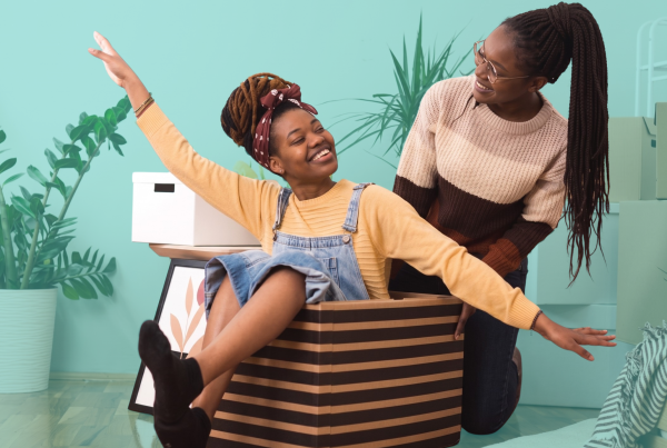 Two friends celebrating in their new home after choosing to co-buy a house together through shared homeownership