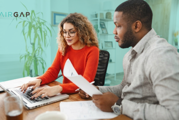 Two co-investors reviewing real estate documents together at a desk with a laptop, with the Pairgap logo in the top left corner.