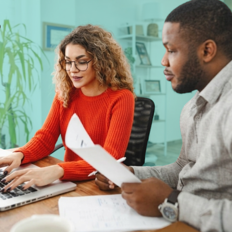 Two co-investors reviewing real estate documents together at a desk with a laptop, with the Pairgap logo in the top left corner.