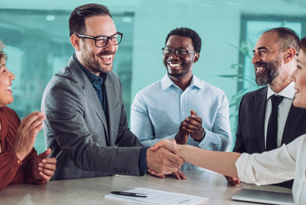 Real estate investment partners shaking hands after discussing a shared property deal, representing co-investing and partnership agreements.