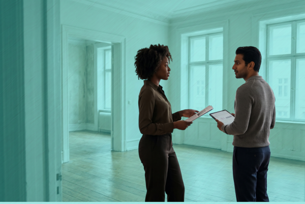 Two prospective co-buyers discussing financing while viewing a spacious home together.