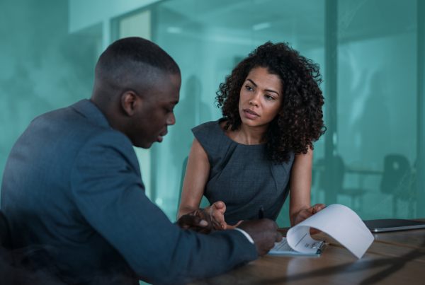 Two co-buyers reviewing paperwork together while discussing a house prenup agreement